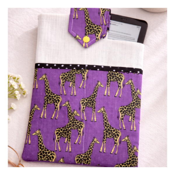 Purple case with giraffe pattern on a white surface with a cup of coffee and glasses.